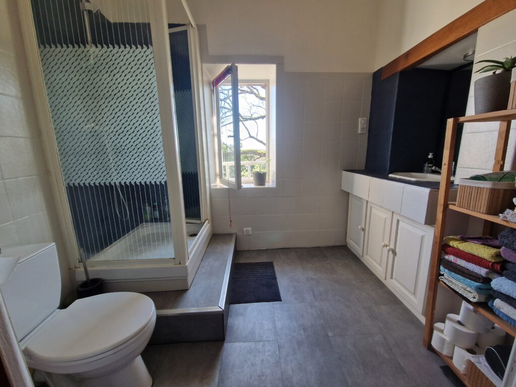 Salle de bain lumineuse avec douche cabine et meuble vasque